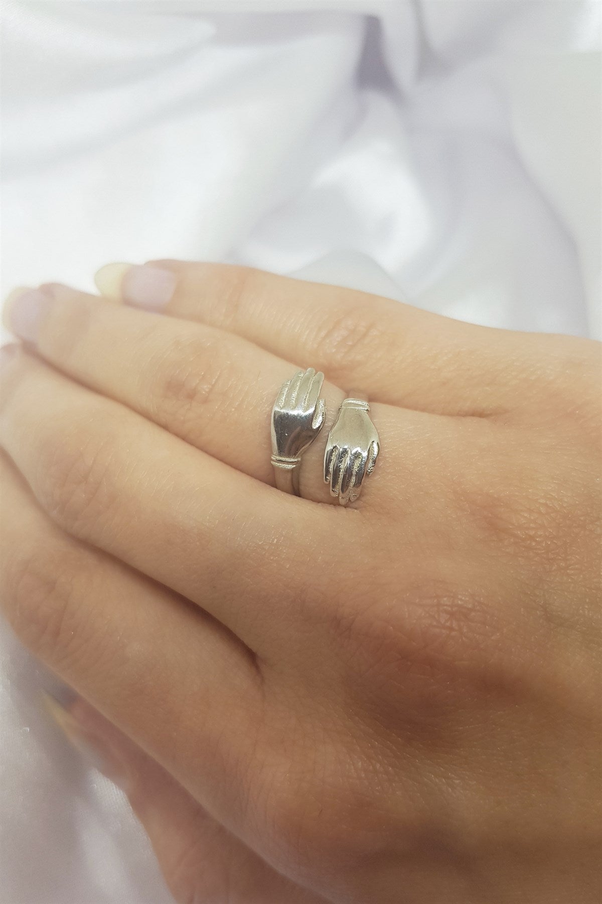 Anillo de plata con manos abrazadas