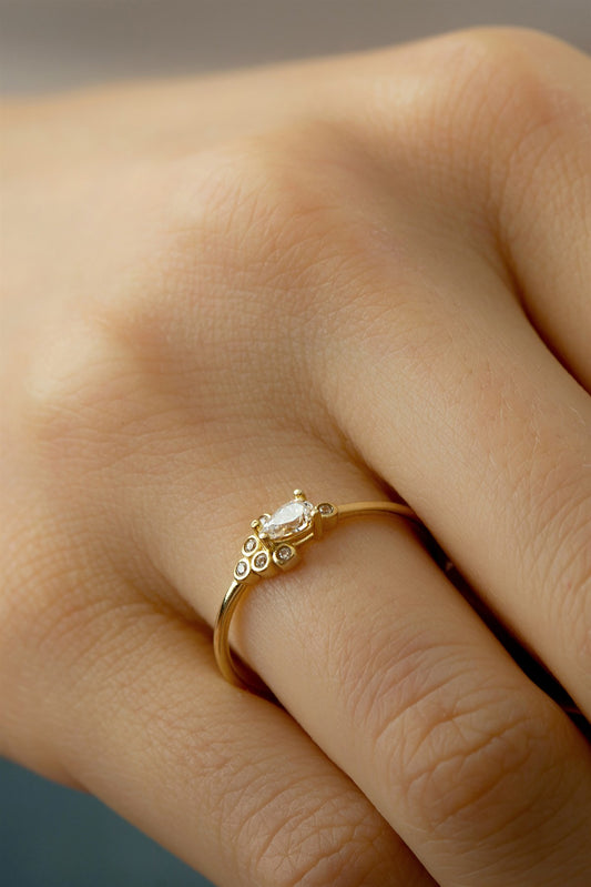 Anillo con diseño de piedras preciosas en forma de gota de oro macizo